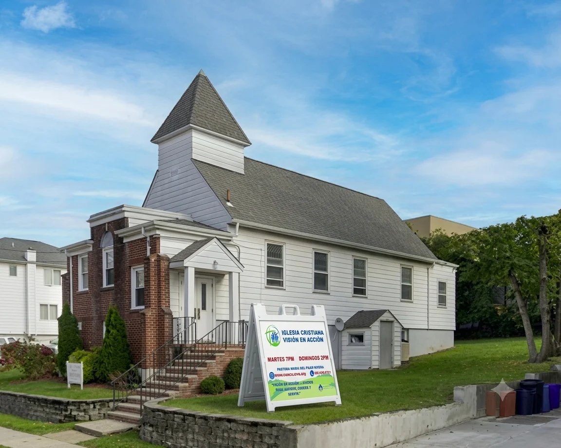Iglesia Cristiana Visión en Acción — edificio blanco con techo gris, aguja, letrero de servicios y cielo azul al fondo