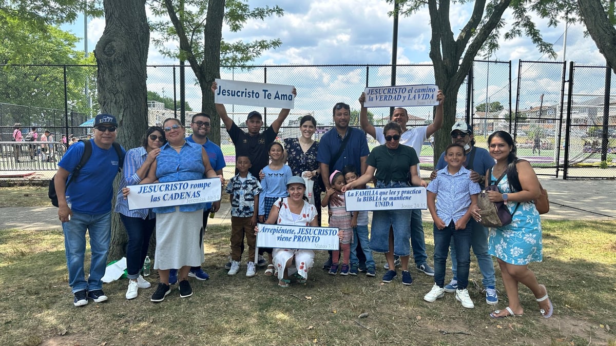 Grupo de personas del Concilio en un espacio abierto del parque sosteniendo carteles durante la campaña evangelística 2025